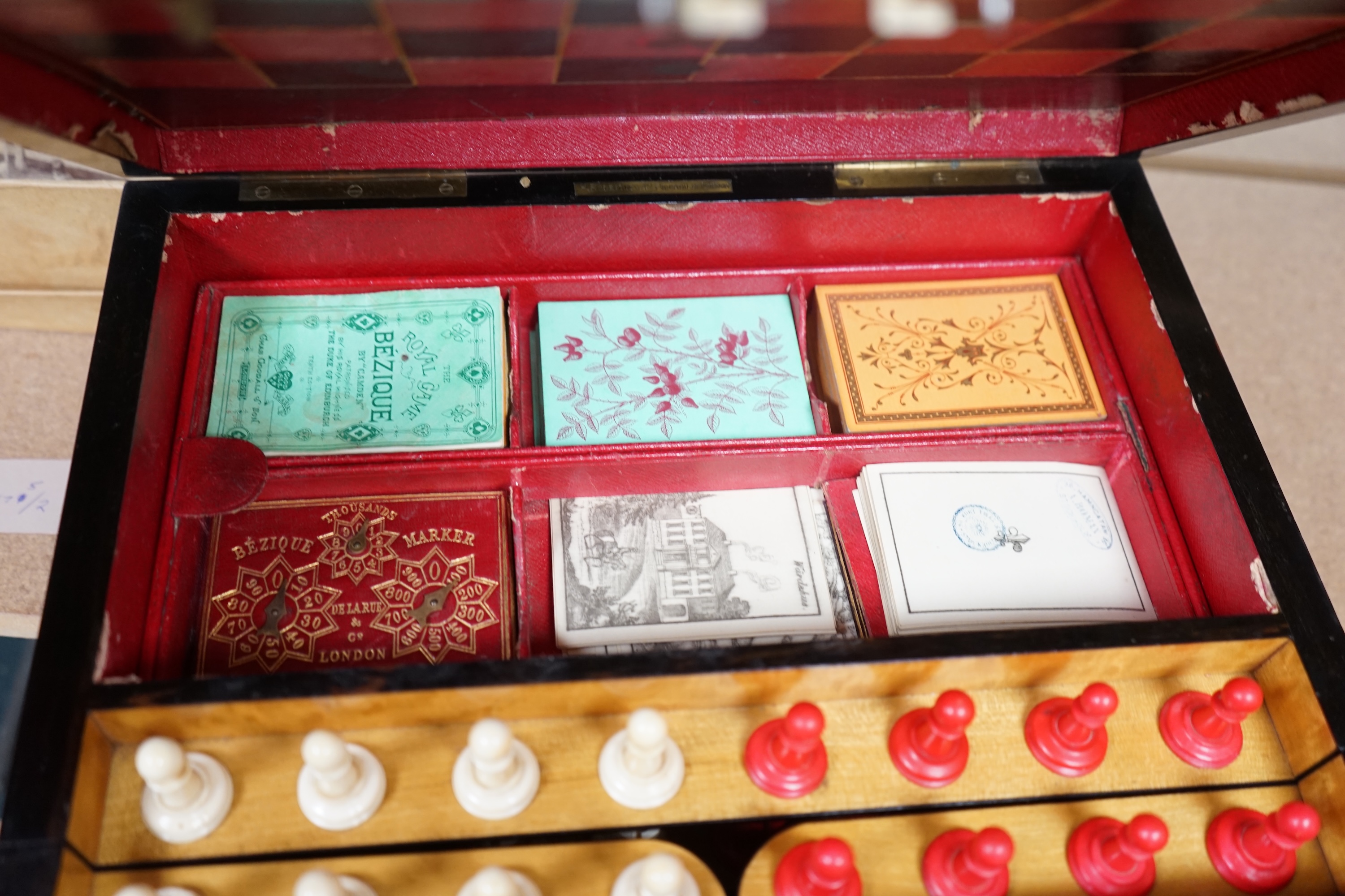 A Victorian coromandel games box with accessories, ivory chess pieces and counters, box 36cm wide x 19cm high. Condition - red interior leather worn and torn in places and box scratched, minor losses to chess pieces. CIT